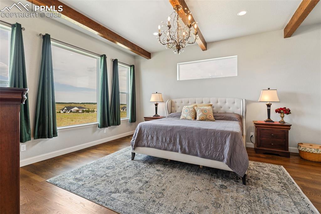 Bedroom featuring beam ceiling, dark wood-style floors, a chandelier, and recessed lighting