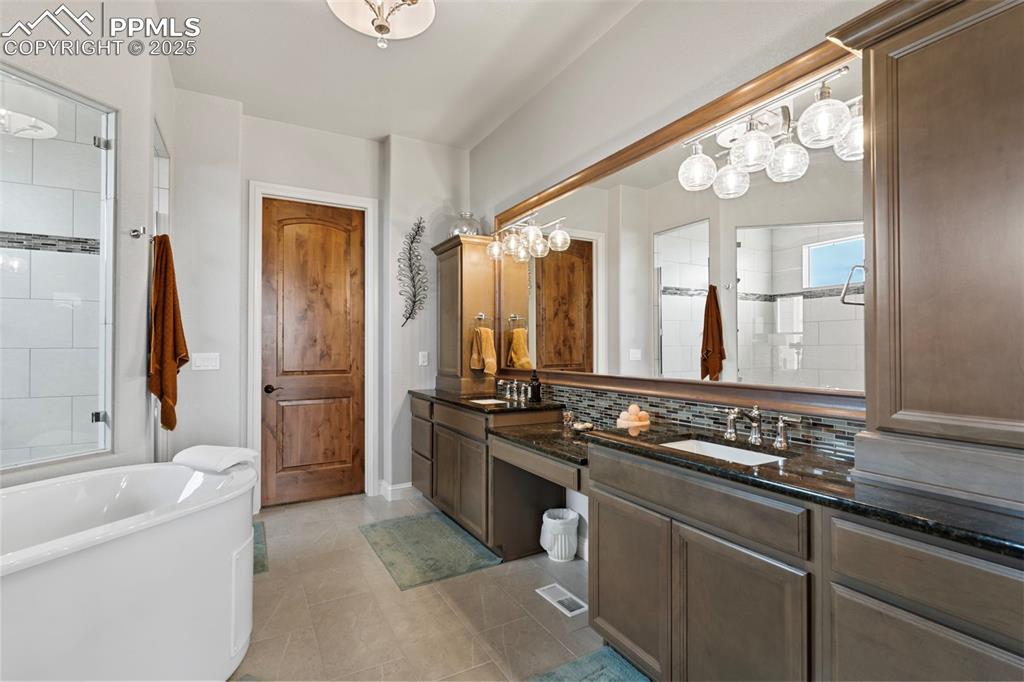 Full bathroom with a soaking tub, tiled shower, decorative backsplash, and light tile patterned floors