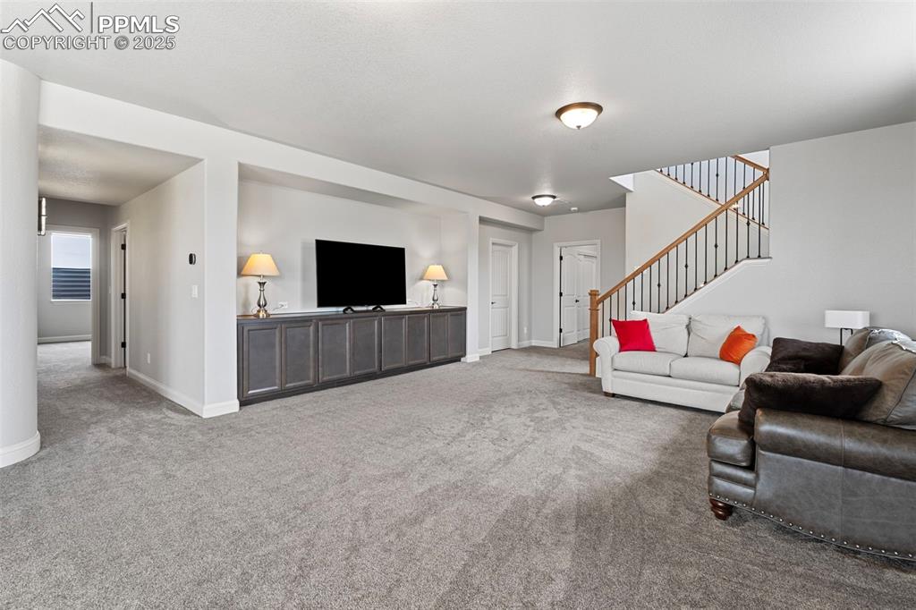 Living area featuring carpet floors and stairs