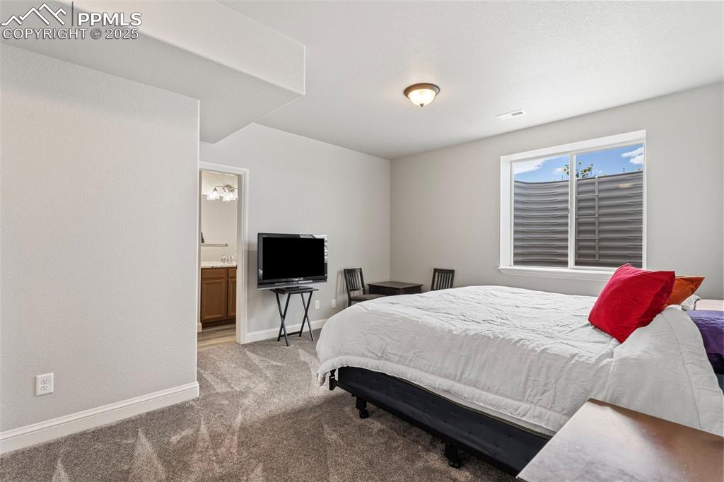 Bedroom featuring light carpet and connected bathroom