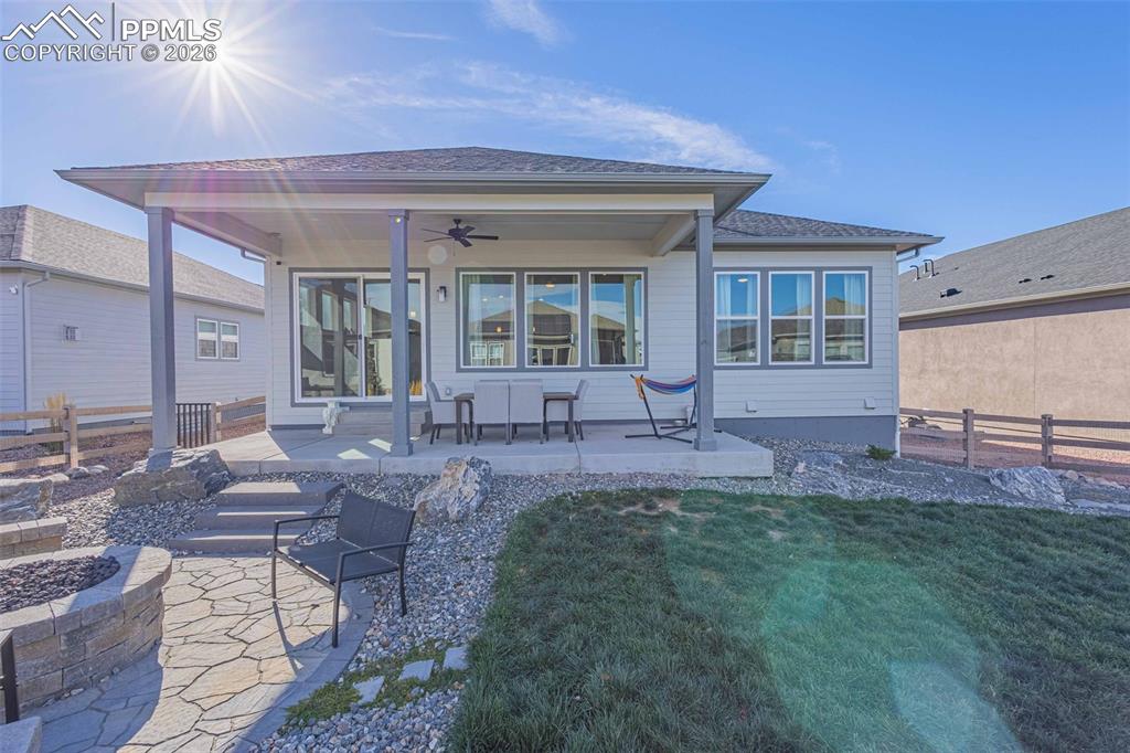 Back of property with a patio, ceiling fan, and a fire pit