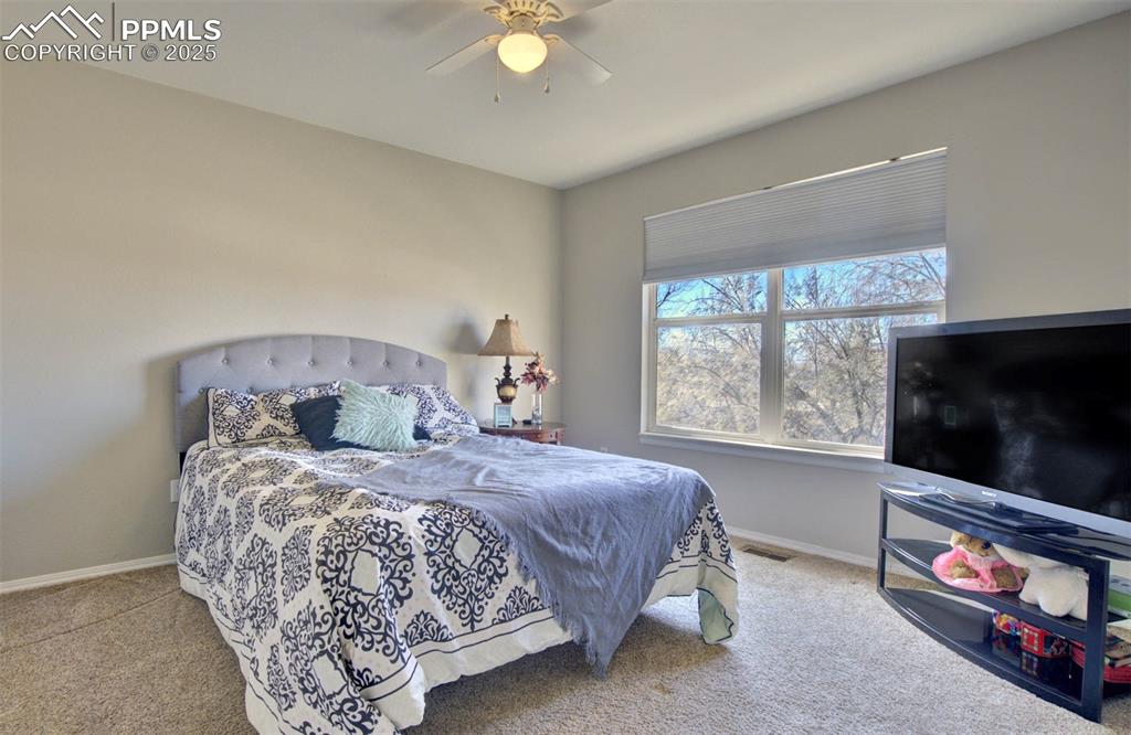 Carpeted bedroom featuring baseboards and a ceiling fan