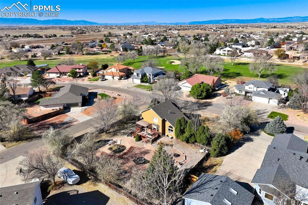 Aerial overview of property's location with nearby suburban area and a mountainous background