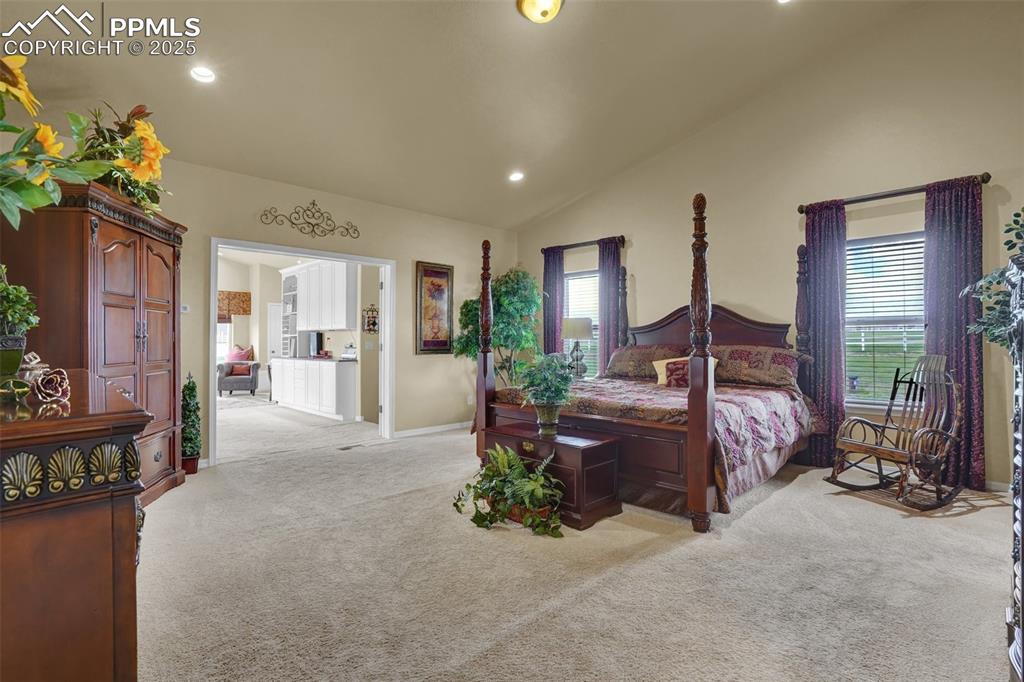 Bedroom featuring lofted ceiling, light carpet, baseboards, and recessed lighting