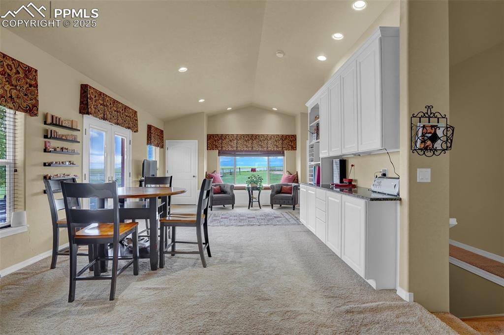 Bonus room off of primary suit featuring baseboards, light colored carpet, vaulted ceiling, french doors, and recessed lighting