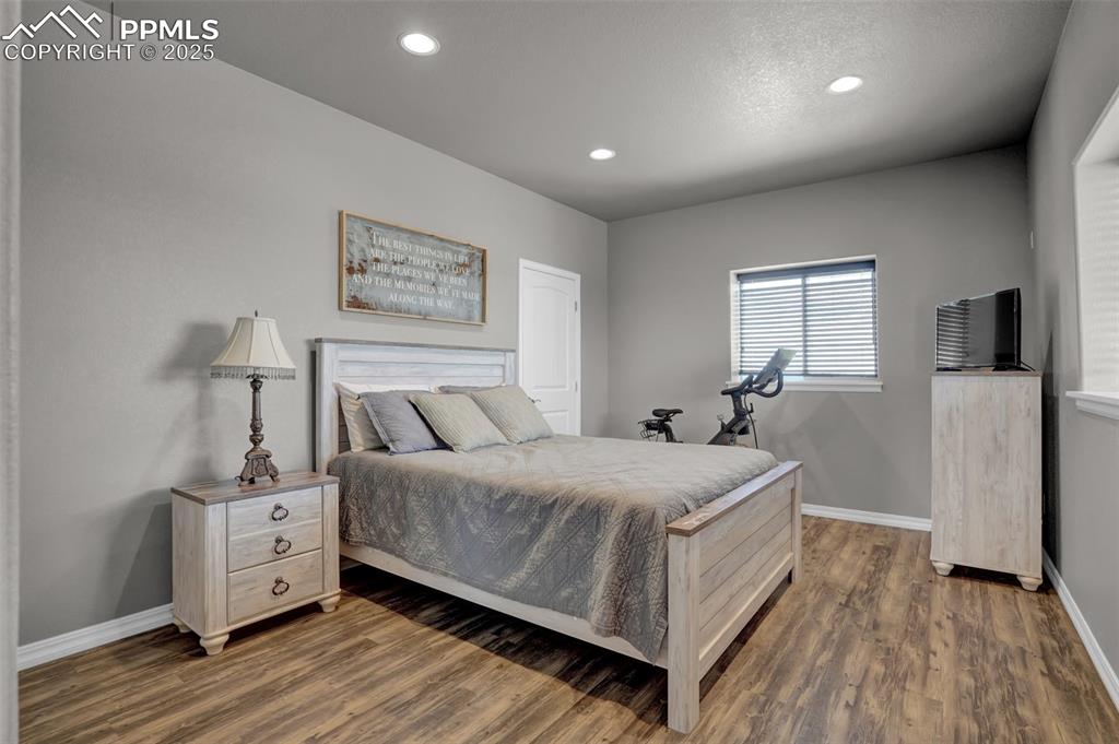 Bedroom featuring dark wood-style floors, baseboards, and recessed lighting