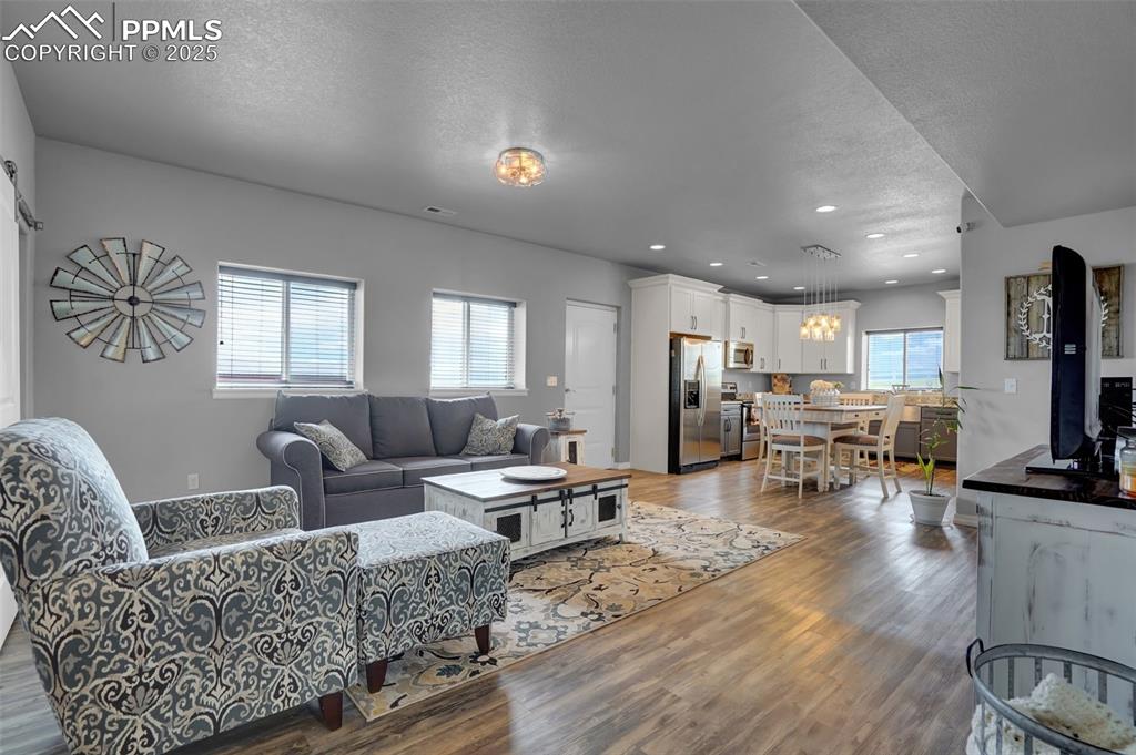 Living area featuring light wood finished floors, plenty of natural light, and a textured ceiling