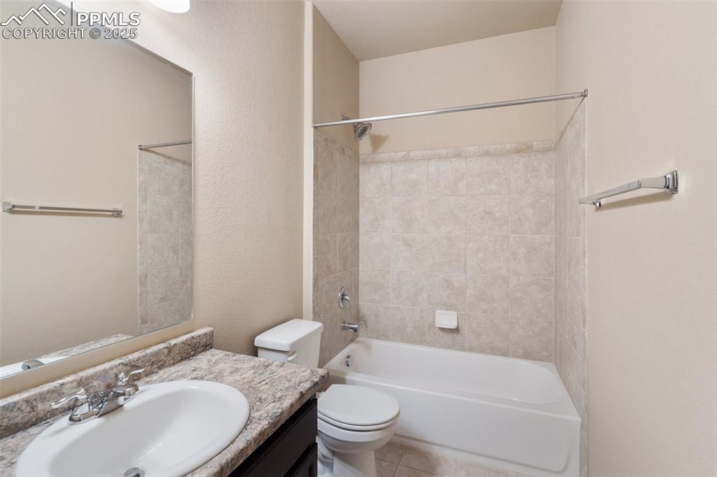 Main Level Hall Bathroom - Full bath featuring shower / bathtub combination, vanity, and a textured wall