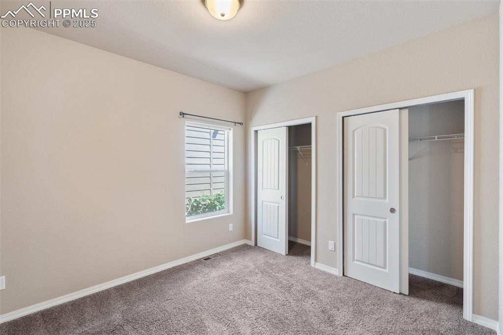 Basement Bedroom on main Level - Unfurnished bedroom featuring two closets and carpet flooring