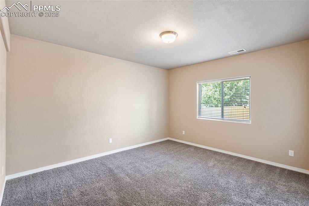Basement Bedroom - Unfurnished room with baseboards and carpet floors