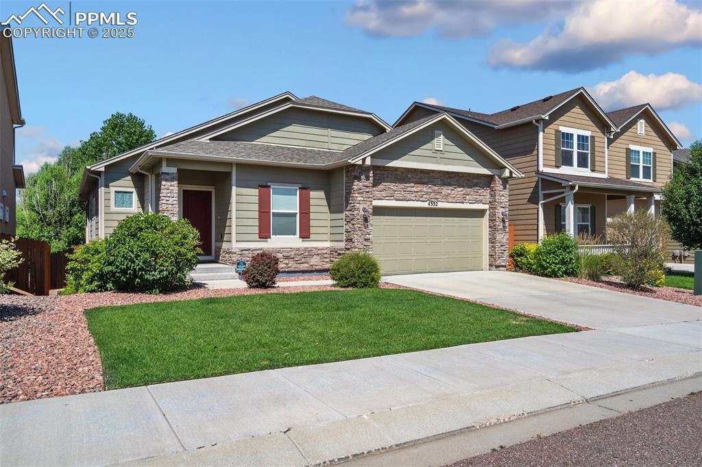 Craftsman-style house featuring concrete driveway, stone siding, and a shingled roof