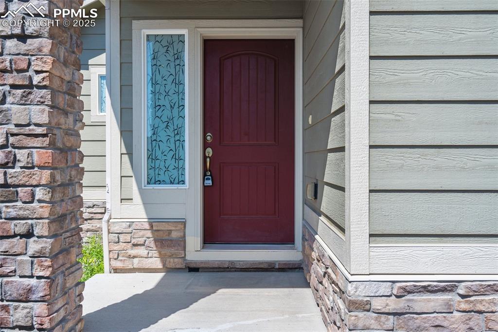 Entrance to property featuring stone siding