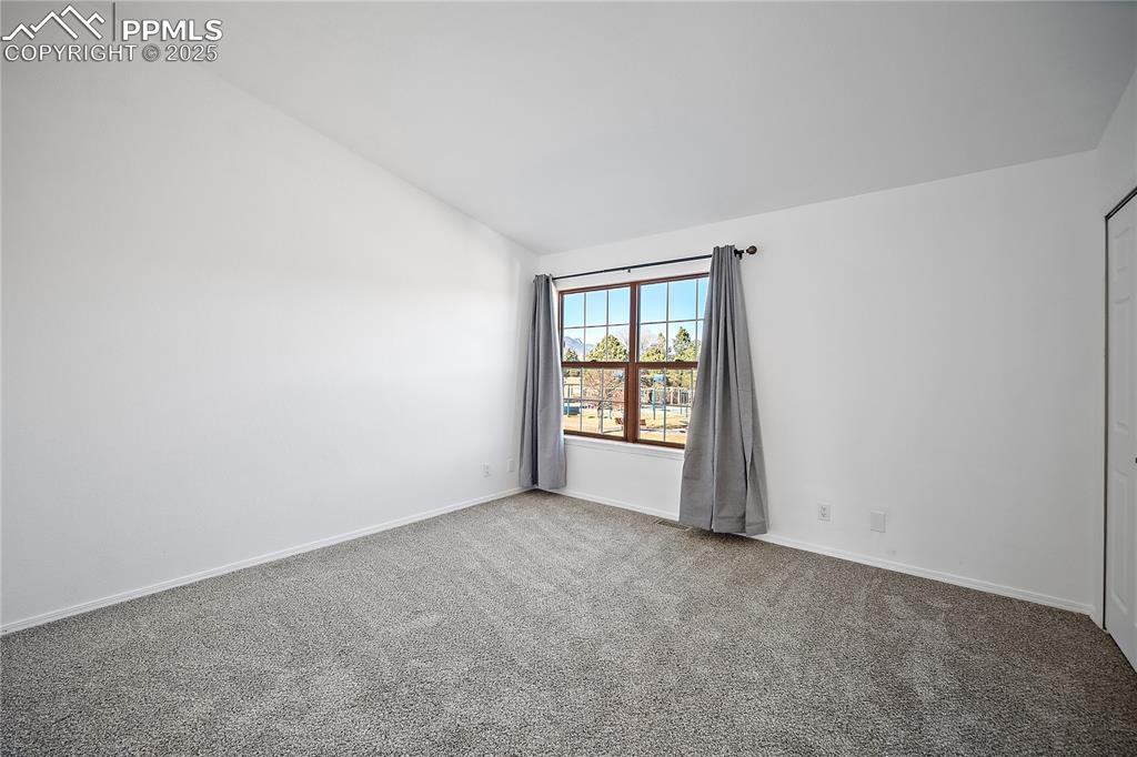 Upstairs bedroom with vaulted ceilings. Large picture window over looks the neighboring park. 