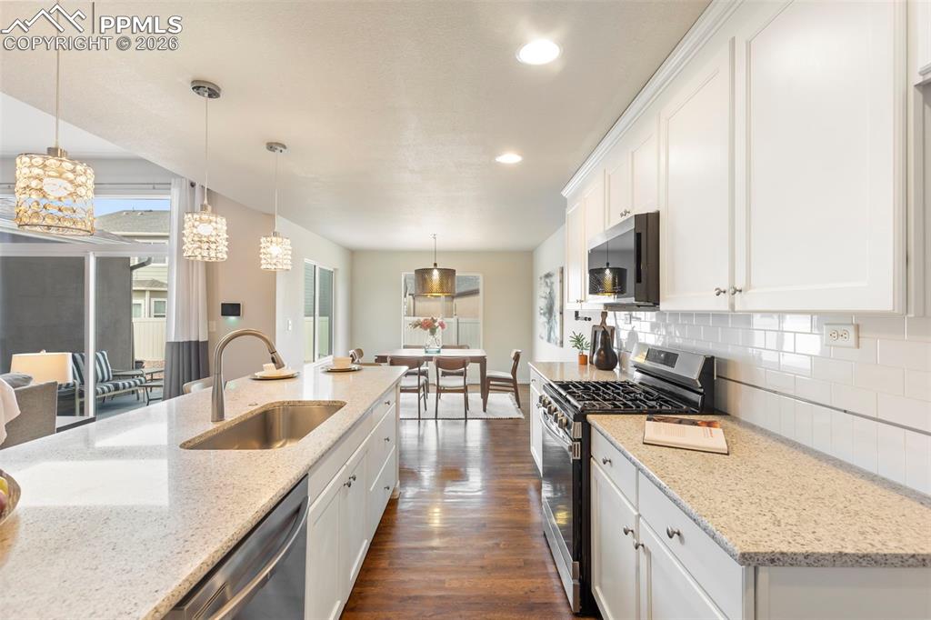 Open kitchen and dining layout showcasing island seating and connection to the great room.