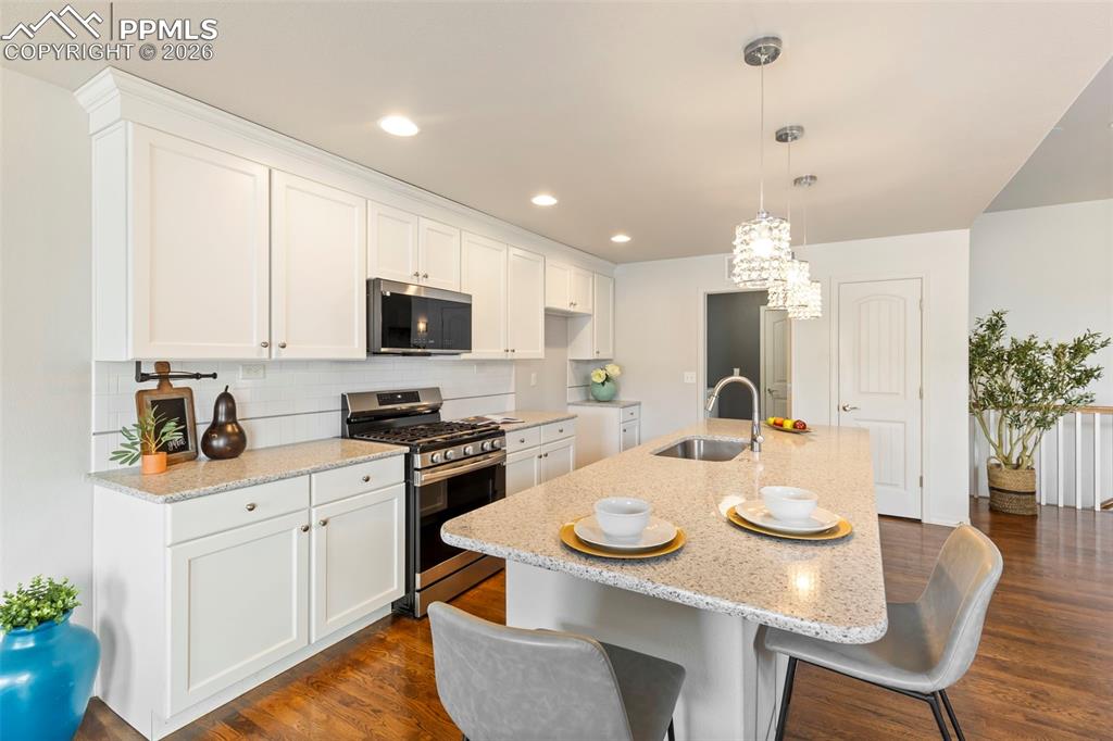 Dining space connected to the kitchen, showcasing hardwood floors and open sightlines.