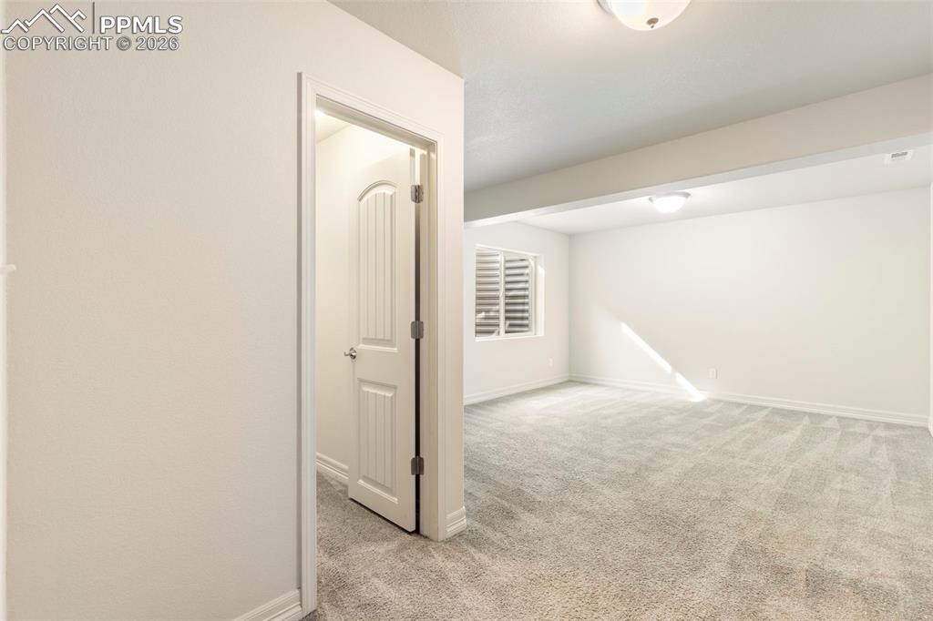 Finished basement bedroom with carpeted flooring, recessed lighting, and egress window