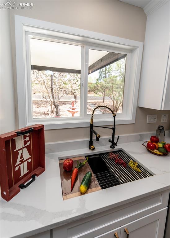 Kitchen view of light stone counters and white cabinetry