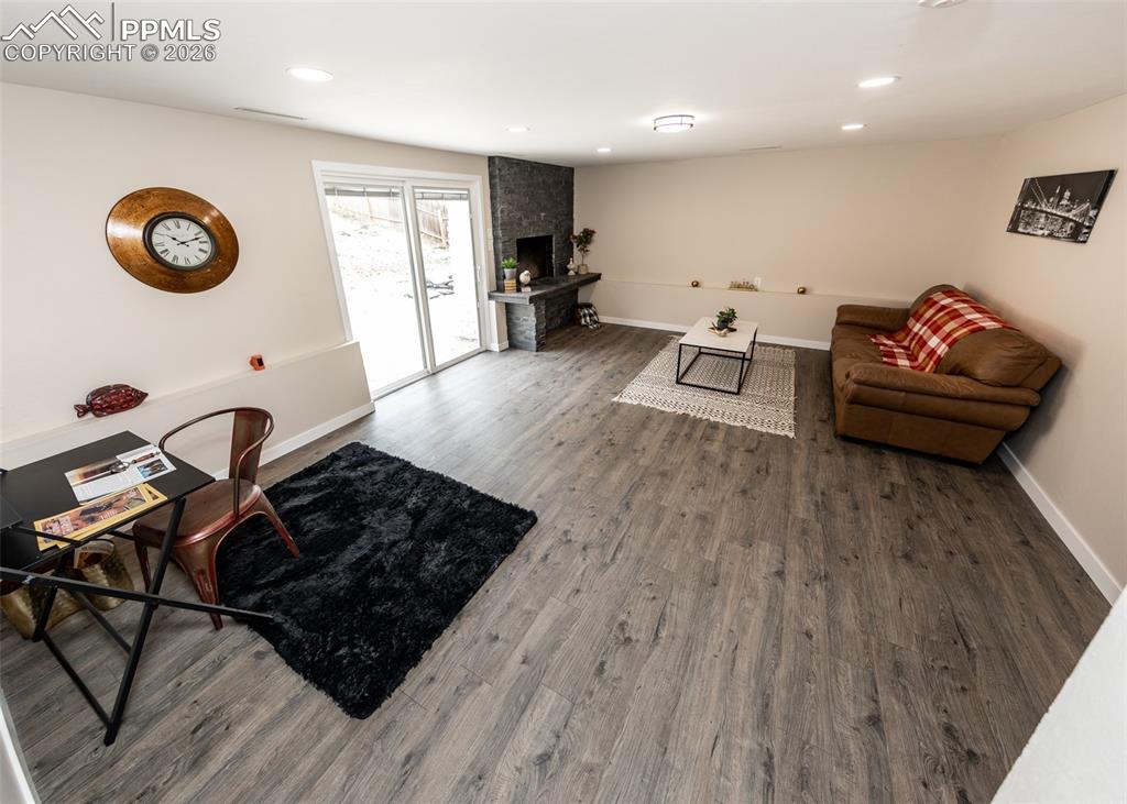 Living area featuring wood finished floors, a fireplace, and recessed lighting