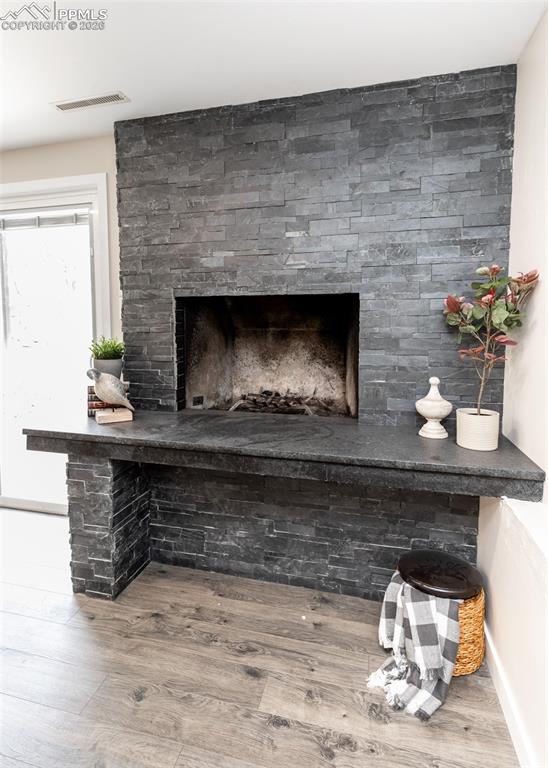 Detailed view of wood finished floors and a fireplace