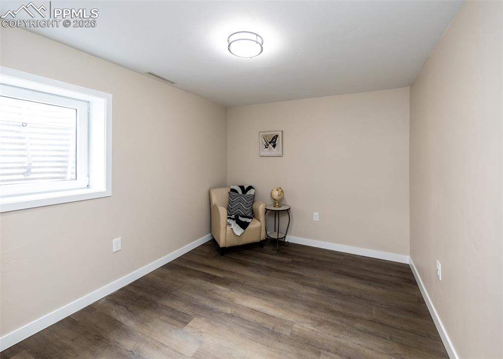 Unfurnished room featuring dark wood-type flooring and baseboards