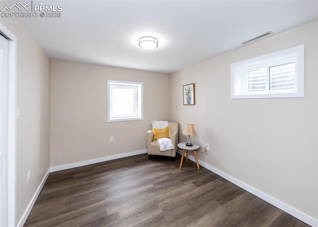 Living area featuring dark wood-style floors and baseboards