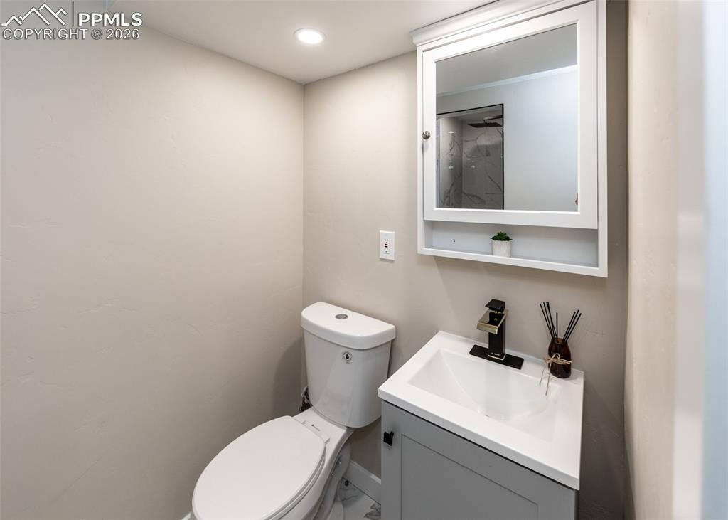 Half bath featuring vanity, recessed lighting, and marble finish floors