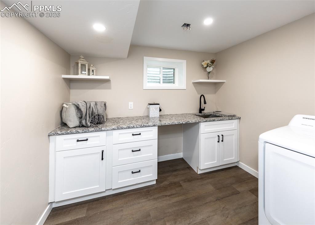 Laundry room with washer / dryer, dark wood-type flooring, and cabinet space