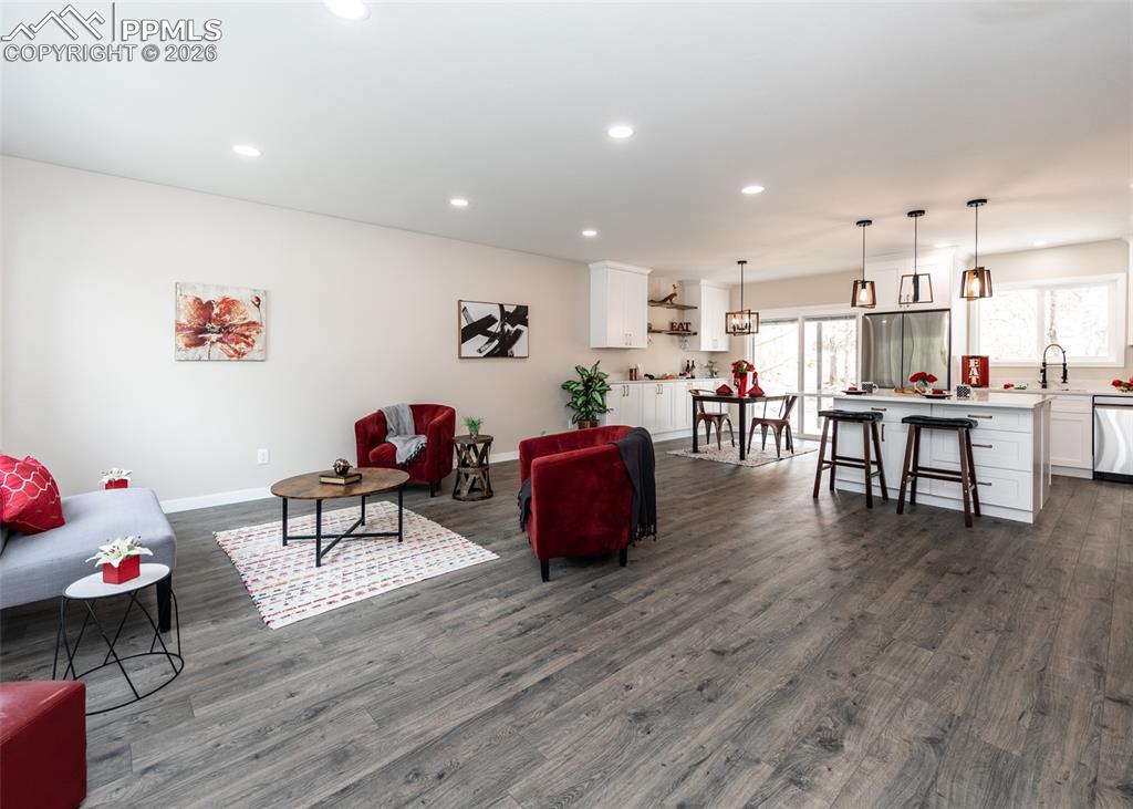 Living area featuring dark wood-style flooring and recessed lighting