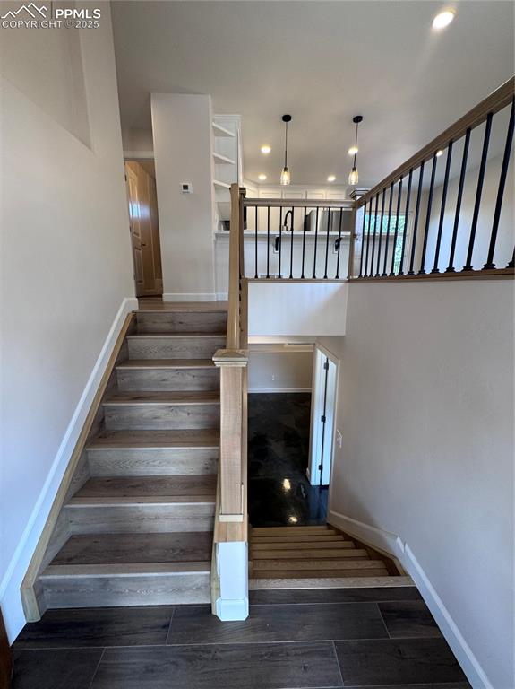 Stairway with wood finished floors and recessed lighting