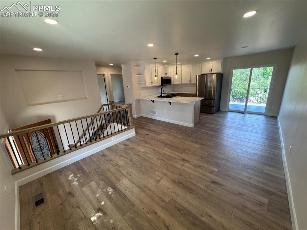 Kitchen featuring open shelves, recessed lighting, white cabinetry, appliances with stainless steel finishes, and a peninsula