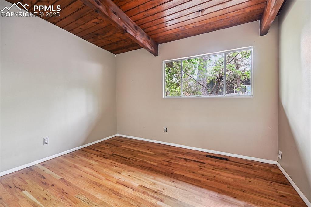 Empty room with wooden ceiling and wood finished floors