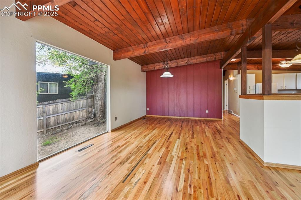 Unfurnished room featuring wood finished floors and a wood ceiling with exposed beams