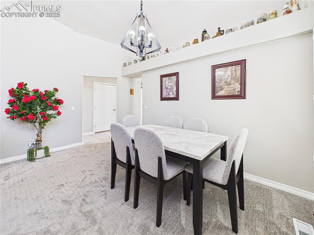 Dining Area – Defined dining space with vaulted ceilings and updated lighting, ideal for gatherings or quiet meals at home.