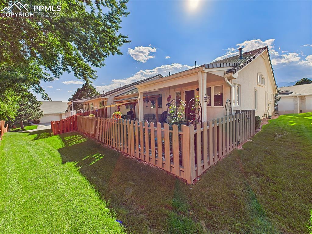 Rear Yard – Fenced backyard with mature trees and privacy fencing, perfect for pets or low-maintenance enjoyment.