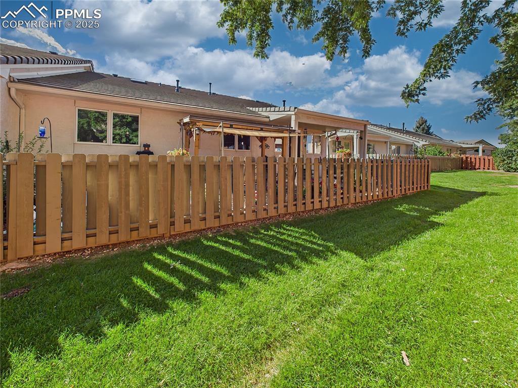 Rear Yard – Beautifully maintained green space and extended fencing surround the peaceful outdoor retreat.