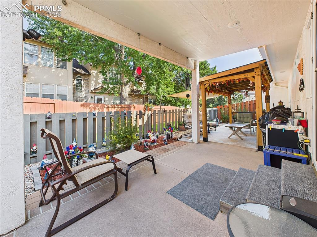 59. Patio Lounge Area – Concrete and paver patio includes a charming pergola-covered seating space—ideal for entertaining or enjoying a quiet afternoon.