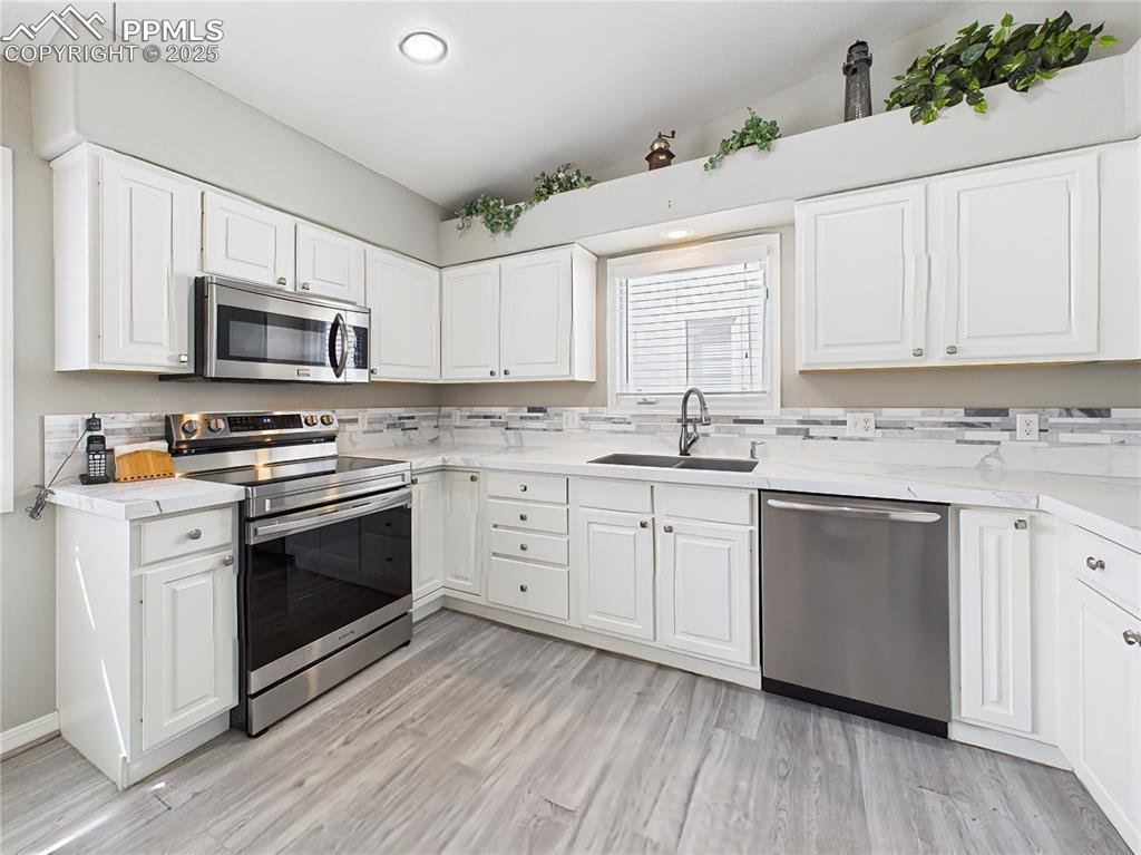 Kitchen – Offers extensive counter space, double-basin sink, and built-in pantry alongside a modern side-by-side refrigerator.