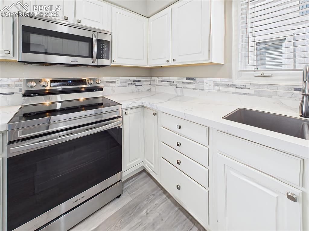 Range & Microwave Detail – Stainless steel appliances including smooth-top range and built-in microwave over ample cabinetry.