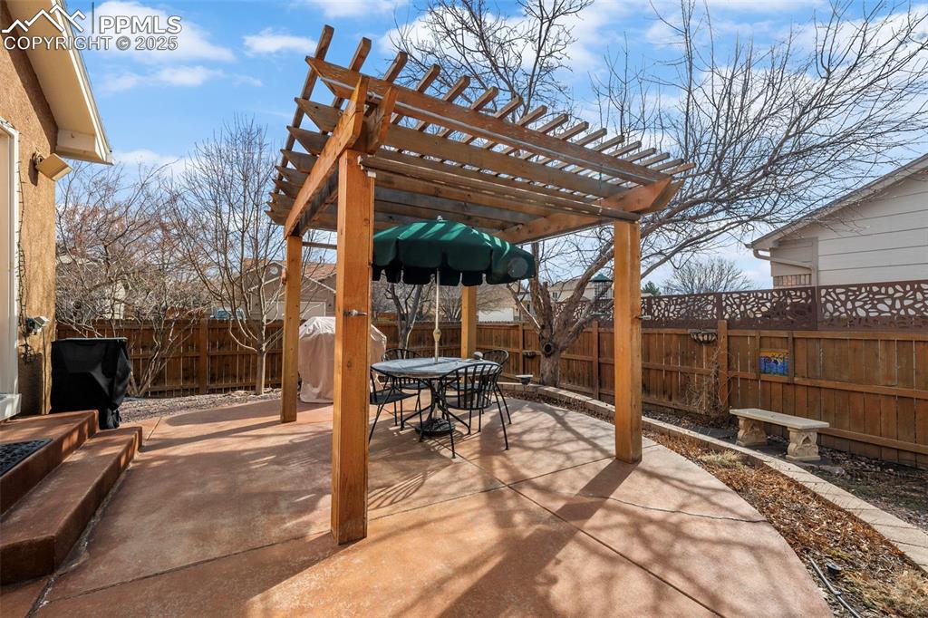 Fenced backyard featuring outdoor dining space, a patio area, and a pergola