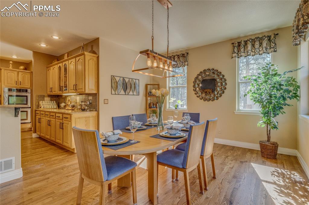 Large dining area off the kitchen with lots of windows for natural lighting.