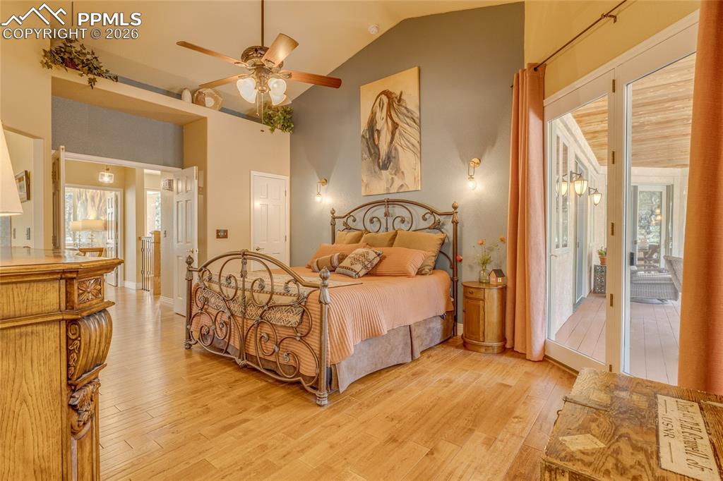 Primary bedroom with vaulted ceilings and wood floors.
