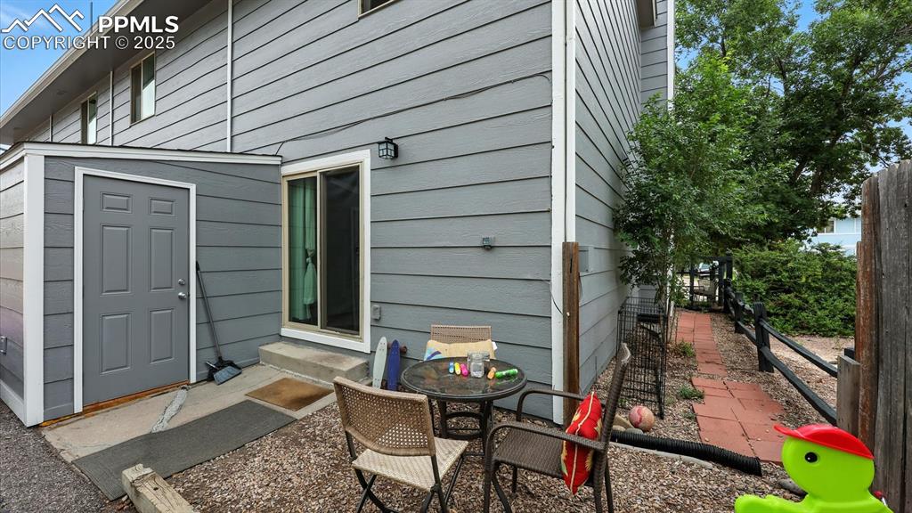 Backyard storage unit and gravel patio area for outdoor BBQs and relaxation.