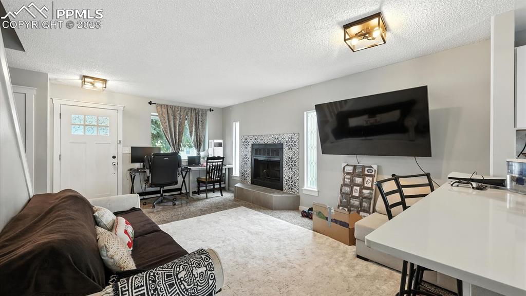 Spacious sunlit Living Room with wood laminate floor and fireplace with decorative tiled surround and raised hearth.