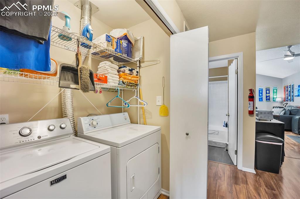 Washroom featuring wood finished floors and washing machine and dryer