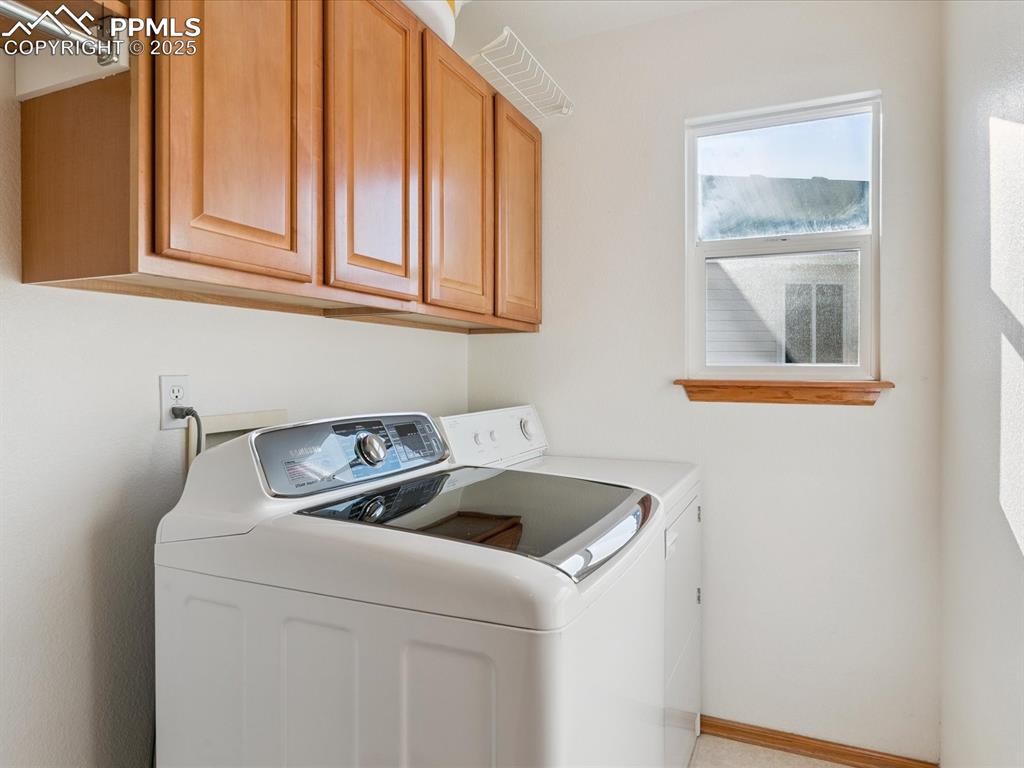 Laundry room featuring cabinet space and separate washer and dryer