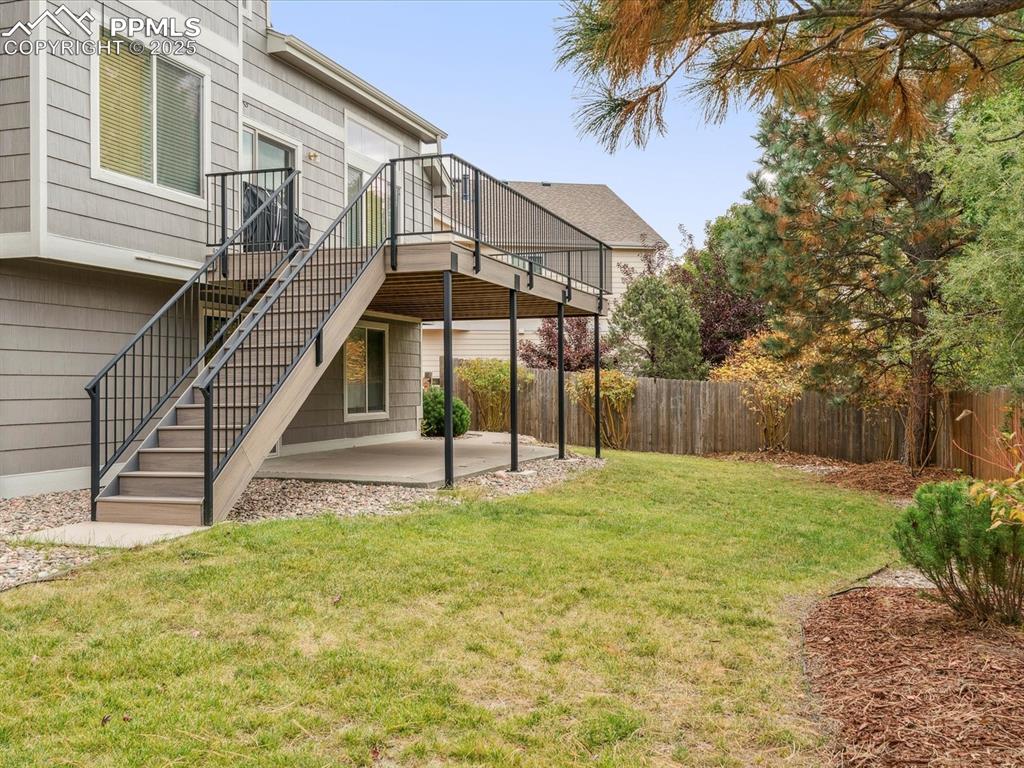Fenced backyard with a patio, stairs, and a wooden deck