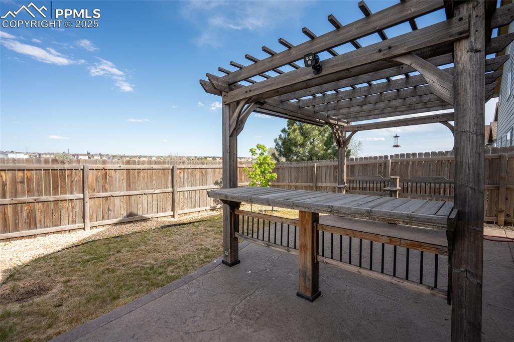 Backyard with stamped concrete, pergola, and fire pit