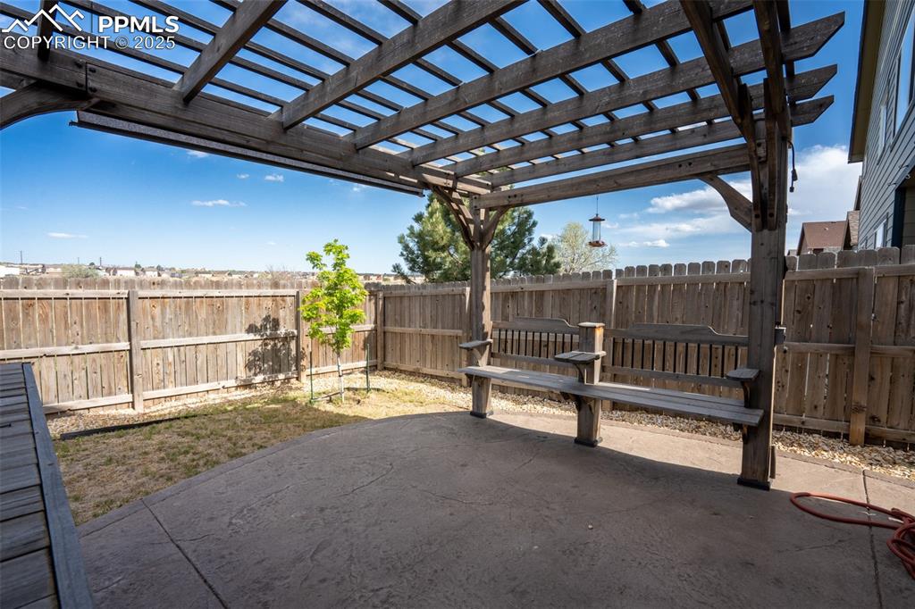 Backyard with stamped concrete, pergola, and fire pit