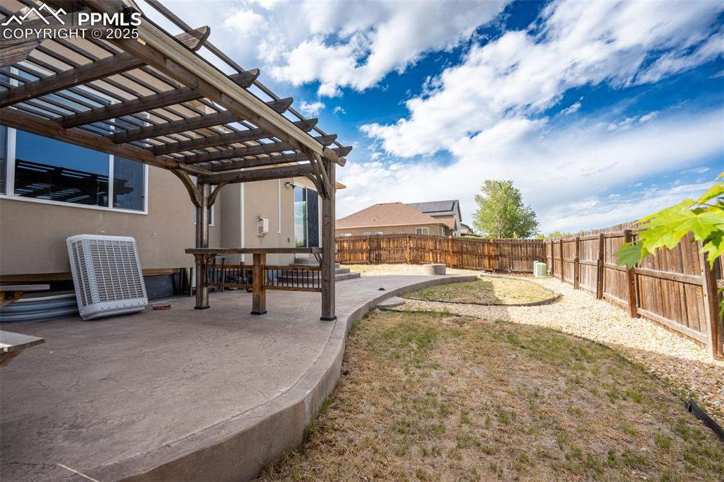 Backyard with stamped concrete, pergola, and fire pit