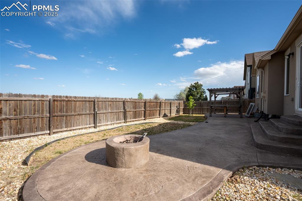 Backyard with stamped concrete, pergola, and fire pit